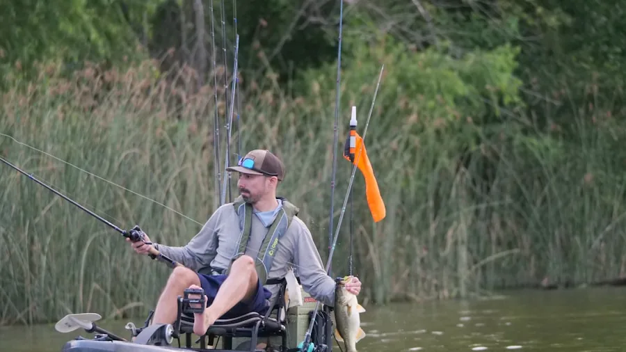 The %product_count% Best Fishing Kayaks 5 Angler sitting in kayak on calm water during peaceful day on the lake