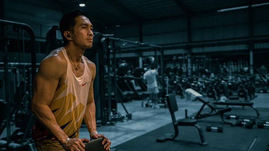 Athletic man wiping sweat from forehead during outdoor summer workout session