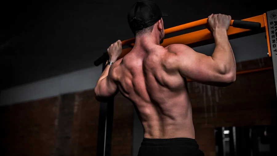 Athletic person performing pull up on bar during outdoor workout training session