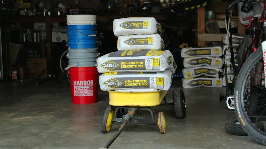 bags of lawn fertilizer and spreader equipment