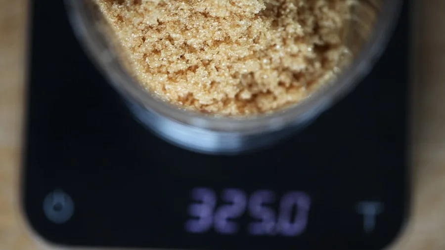 Baker carefully measuring small amounts of ingredients for baking recipe