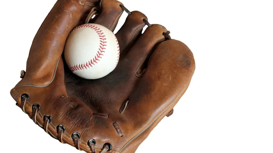 Baseball player carefully conditioning and breaking in a new leather glove during practice