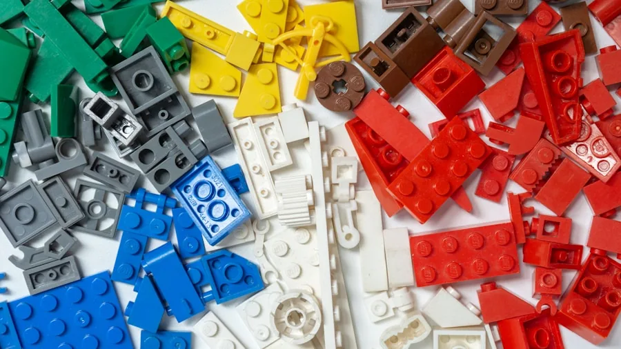 Child arranging colorful plastic building bricks on wooden table for creative construction project