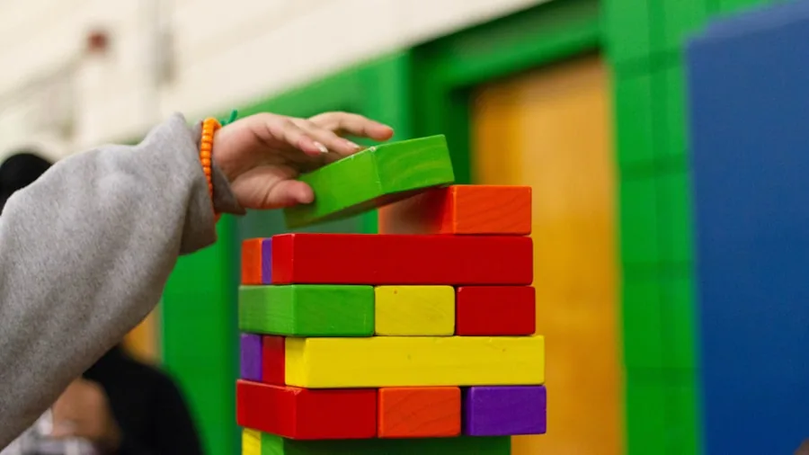 Child focused on building with colorful blocks, demonstrating spatial reasoning and problem-solving skills