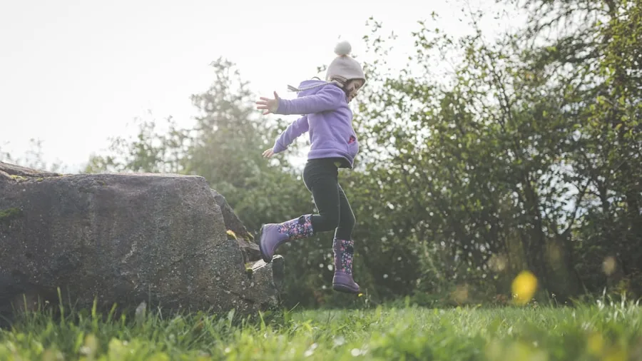 Child mid-jump outdoors on sunny day, experiencing joy and active play in natural setting