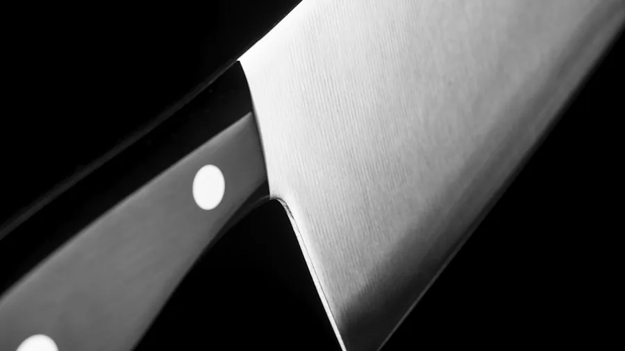 The %product_count% Best Knife Sharpeners 3 Close-up of hands sharpening a kitchen knife on a whetstone with focused technique