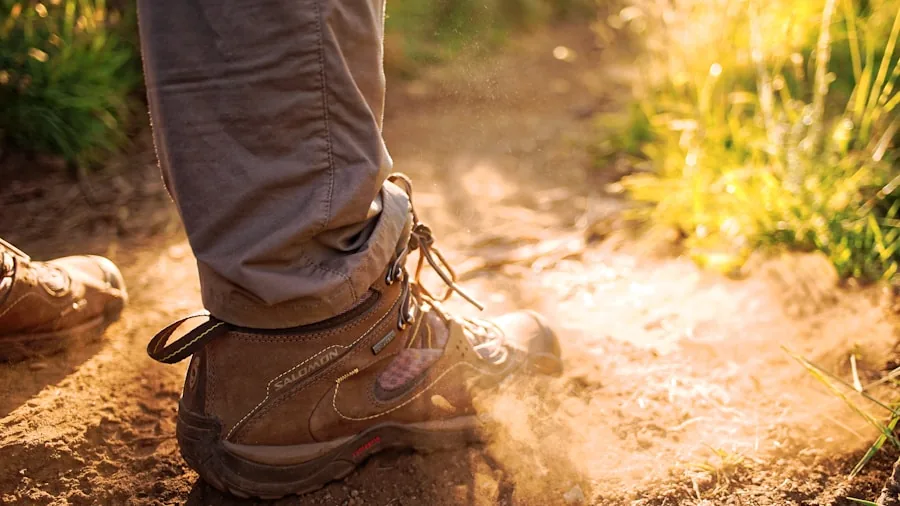 Close-up of hiker inspecting hiking boot material and construction quality outdoors