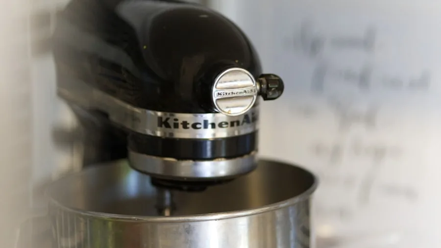 Close-up of milk being frothed with visible foam texture and motion in a kitchen setting