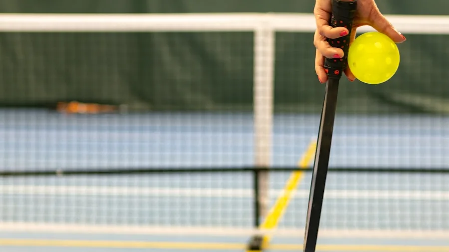 The %product_count% Best Pickleball Paddles for Beginners 3 Close-up of player's hand gripping pickleball paddle during outdoor game