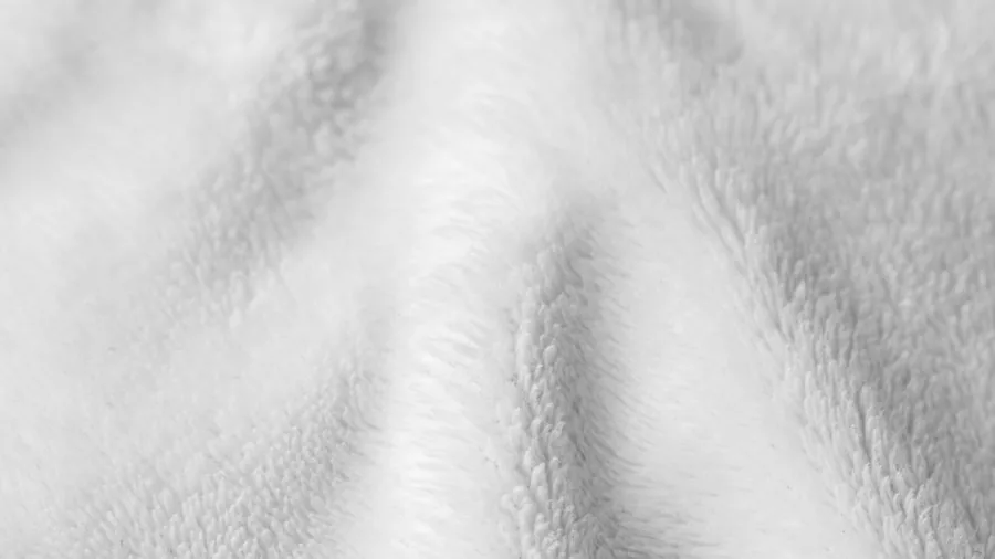 Close-up of soft, breathable fabric texture with gentle lighting, emphasizing comfort and quality material for infant care