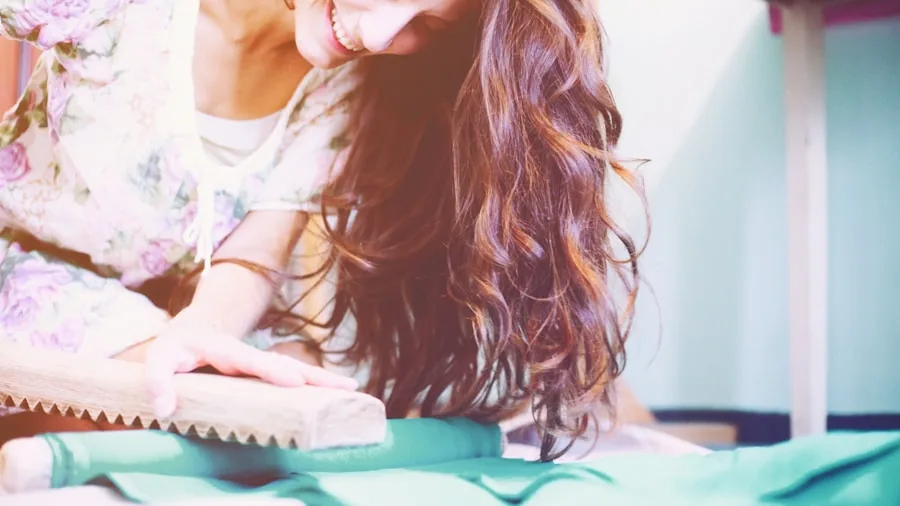 Close-up of someone ironing a delicate silk garment with smooth, careful strokes on an ironing board