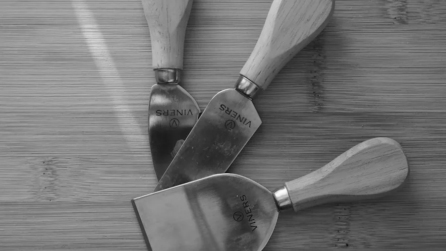 The %product_count% Best Charcuterie Boards 3 Close-up of stainless steel cheese knives and bowls arranged on a wooden charcuterie board during a gathering