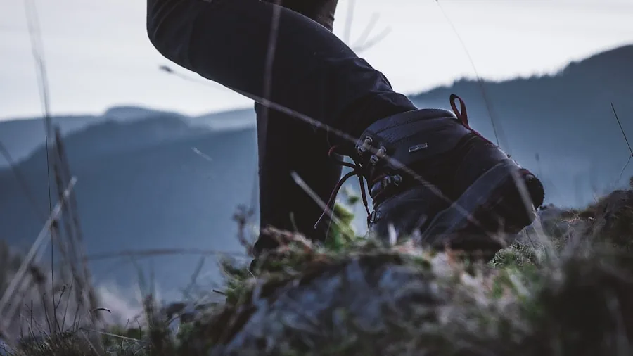 The %product_count% Best Trekking Boots 5 Close-up of trekker inspecting hiking boot upper construction and fabric durability in outdoor setting