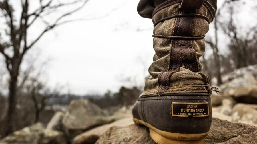 Close-up of weathered leather hiking boots on a mountain trail during a backpacking adventure