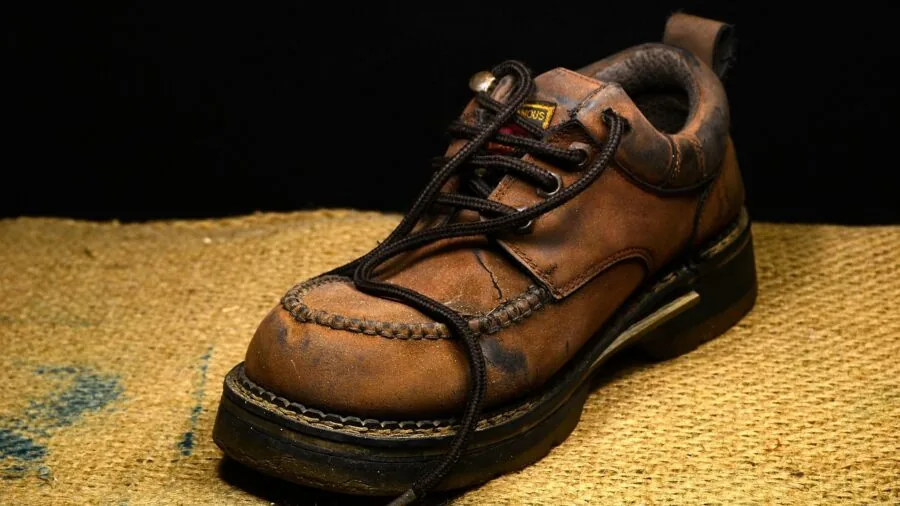 The %product_count% Best Hiking Boots 6 Close-up of worn hiking boot sole on mountain trail showing wear patterns and tread usage