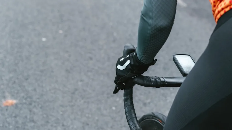 Cyclist on road bike checking phone stored in shorts pocket during outdoor ride