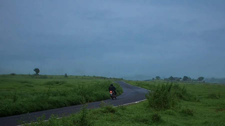 Cyclist riding on a scenic rural road during a long-distance cycling journey through countryside