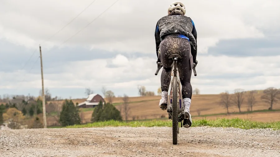Cyclist riding on rocky gravel trail through natural terrain with trees in background