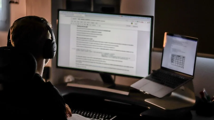Developer coding at computer workstation with external display in modern office environment