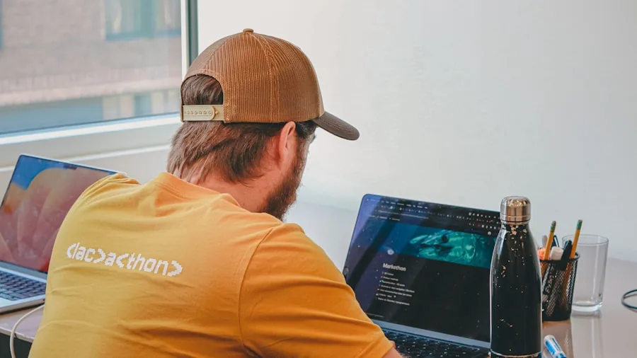 Developer focused on laptop screen while working at desk with natural lighting