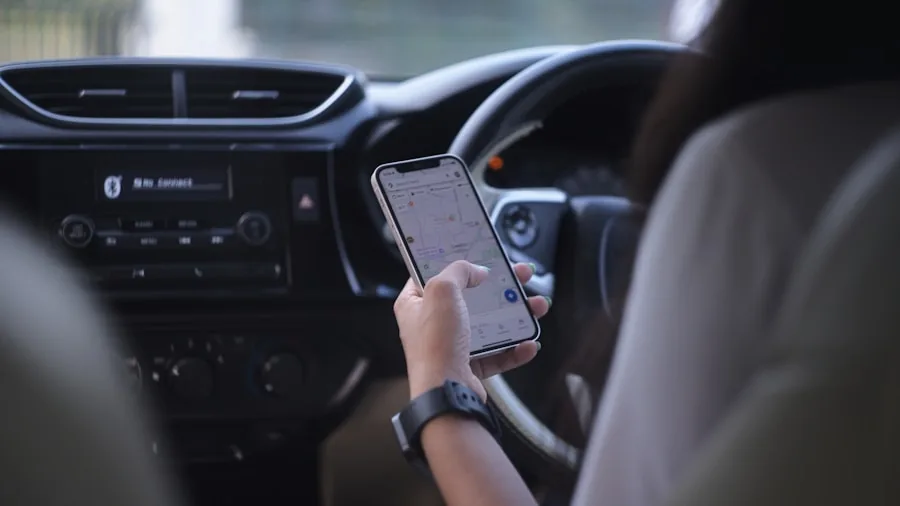 Driver viewing mobile phone inside vehicle, representing wireless connectivity and app experience while driving
