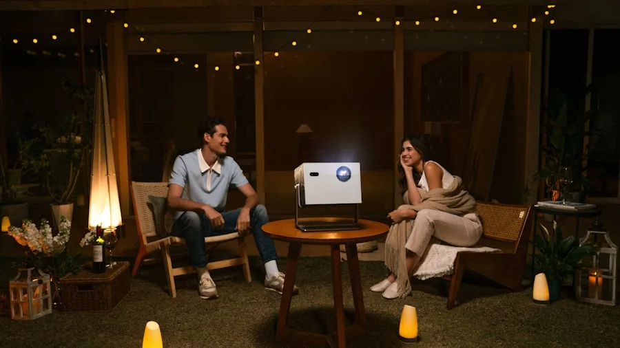 The %product_count% Best Outdoor Projectors 3 Family enjoying outdoor movie night in backyard with projection screen and comfortable seating under stars