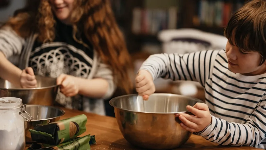 Family gathered in kitchen preparing large holiday meal together with multiple dishes cooking