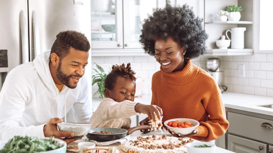 Family preparing and cleaning up after cooking dinner in modern kitchen