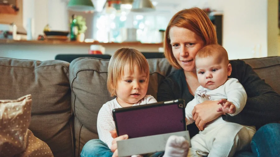 Family using multiple devices connected to home WiFi network in living room