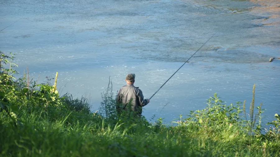Fisherman casting line in scenic freshwater river during daytime