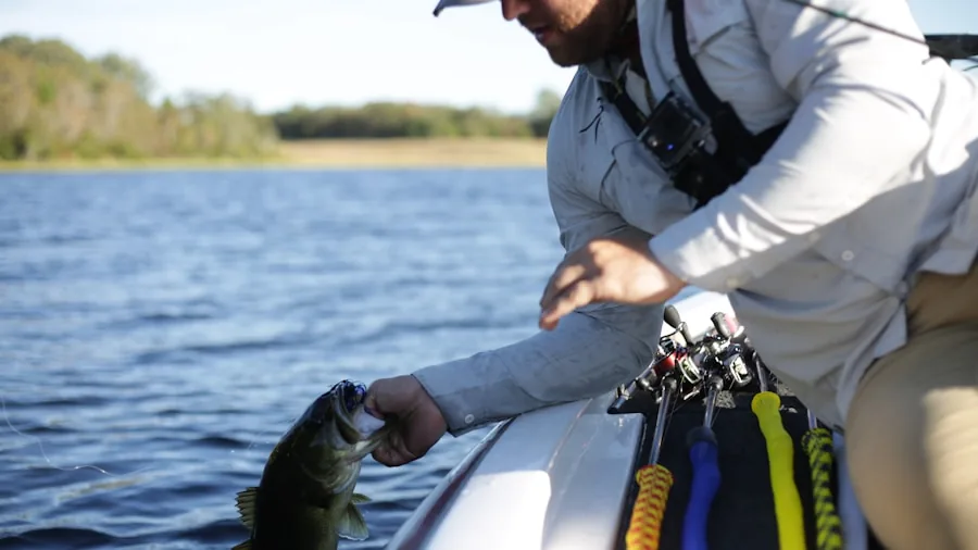Fisherman inspecting hard plastic lure by water's edge in natural daylight