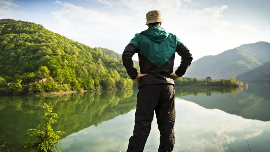 Fisherman looking at water surface to spot fish beneath, demonstrating importance of clear visibility while fishing