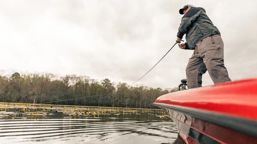 The %product_count% Best Fishing Kayaks 3 Fisherman standing on stable kayak while casting rod on calm water