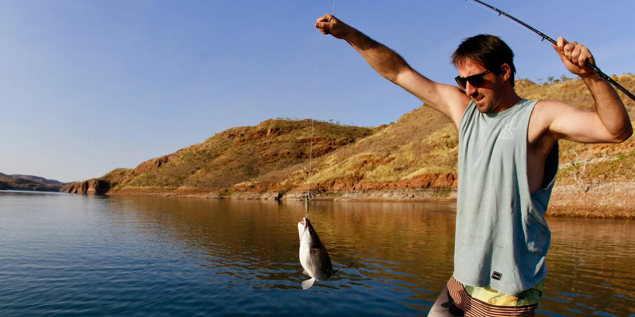 Fisherman wearing polarized sunglasses while fishing on sunny water