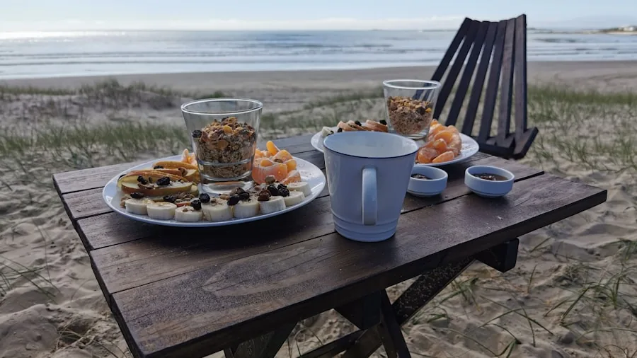 Friends grilling food at a beach campsite with portable equipment and ocean view