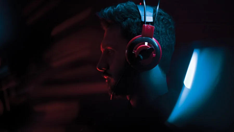 Gamer wearing earbuds focused on screen during gaming session
