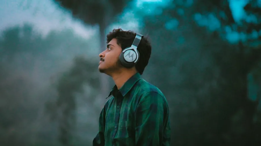 Gamer wearing headphones focused on gaming experience with dramatic lighting