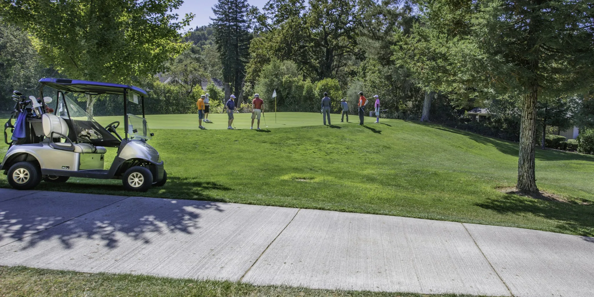 Golfer walking across golf course carrying golf bag during round of golf