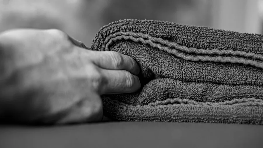hands compressing mattress during cleaning