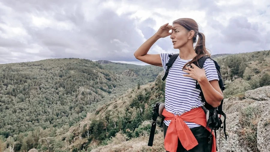 The %product_count% Best Hiking Pants 3 Hiker performing a squat stretch on a scenic mountain trail to test pants mobility and comfort