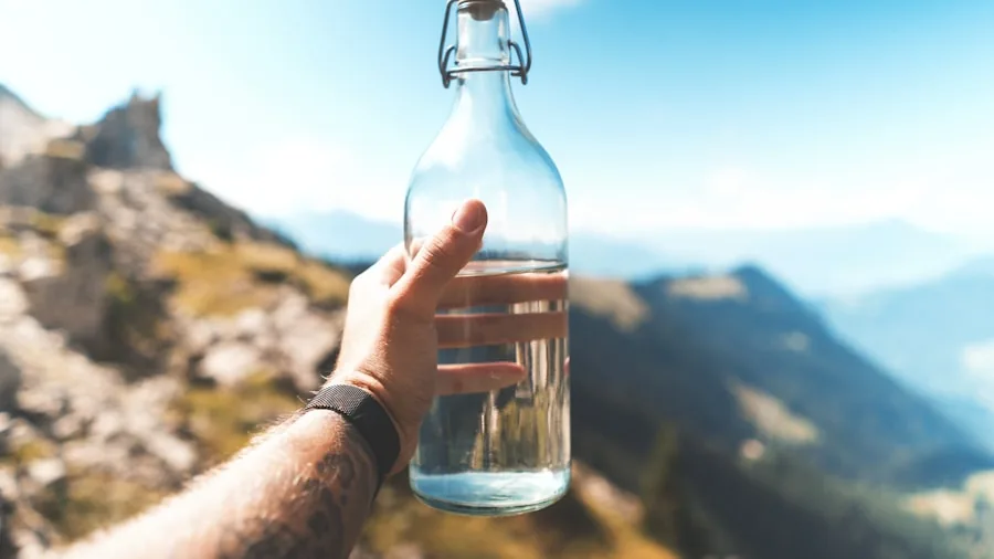 Hiker with stainless steel water bottle on outdoor trail