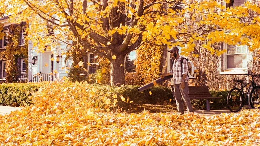 Homeowner operating a leaf blower while maintaining their yard during fall cleanup