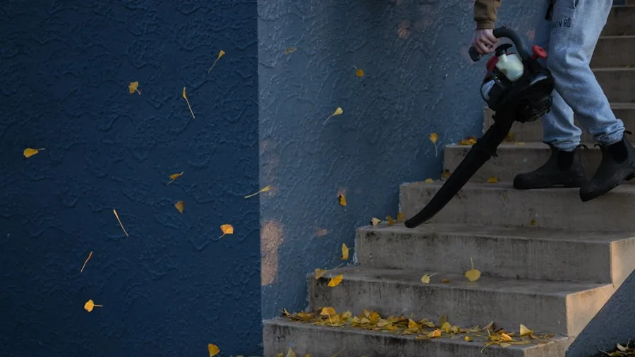 Homeowner raking fallen leaves in residential yard during fall season