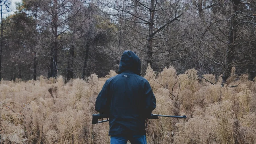 The %product_count% Best Hunting Rangefinders 2 Hunter in camouflage aiming rifle in forested wilderness during daytime hunting