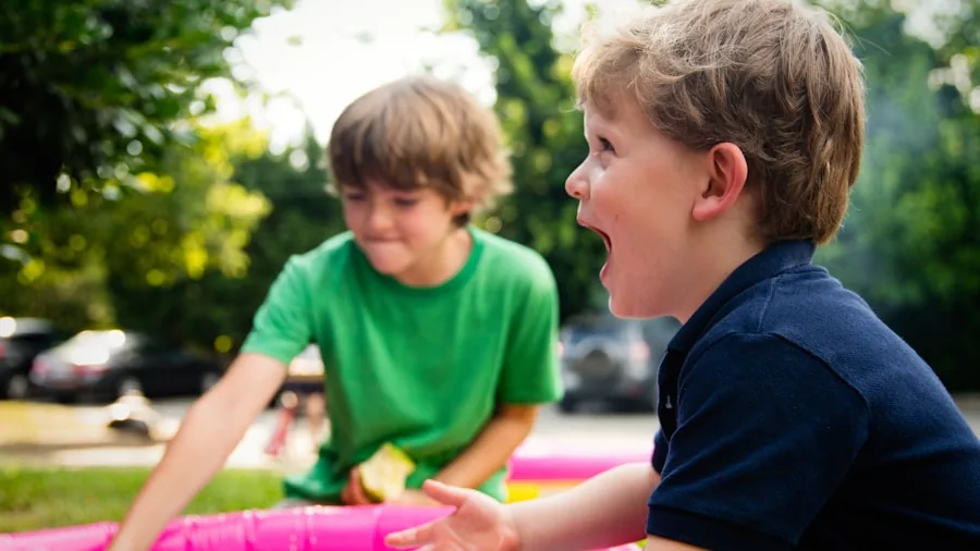 Kids sitting around a table playing board games, focused on gameplay and family bonding