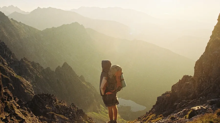 Man hiking on outdoor trail wearing backpack, demonstrating proper walking form on natural terrain