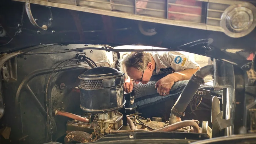 The %product_count% Best Remote Starters 6 Mechanic performing maintenance work under vehicle hood in garage setting