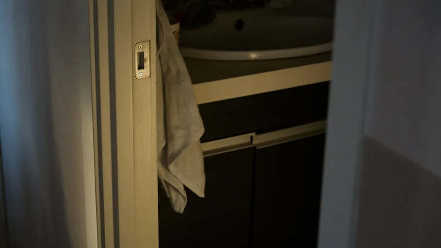 Neatly organized stack of folded towels in a bright bathroom linen cabinet