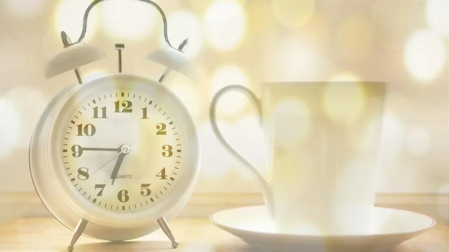 The 9 Best Alarm Clocks 6 Older adult reaching toward bedside alarm clock in morning light bedroom setting