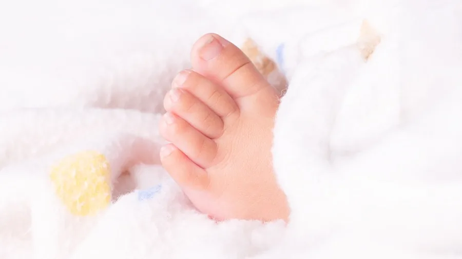 Parent carefully examining baby's delicate skin during diaper change for comfort and safety